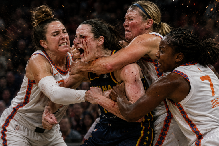A satirical sports image shows Caitlin Clark being grabbed and surrounded by several furious opposing basketball players during a chaotic on-court confrontation.